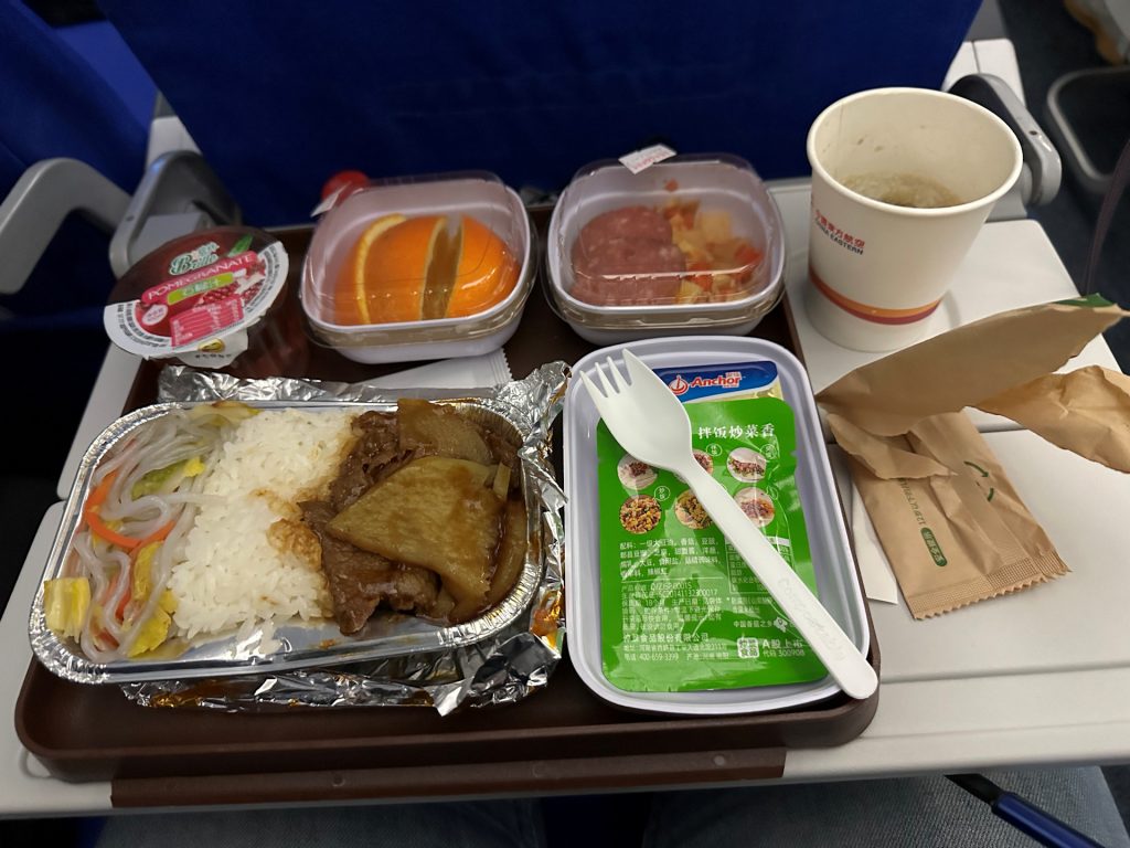 Dinner on our return flight. Listed as beef with rice, some noodles, a side salad with salami, a sauce sachet, orange slices, and pomegranate juice.